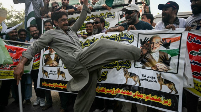 Un commerçant donne des coups de pied sur la photo du Premier ministre indien Narendra Modi lors d'une manifestation contre l'Inde à Karachi, le 29 avril 2025.