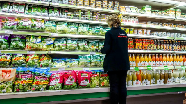 Un employé de Monoprix stocke des articles sur une étagère dans un emplacement du supermarché à Dunkerque.