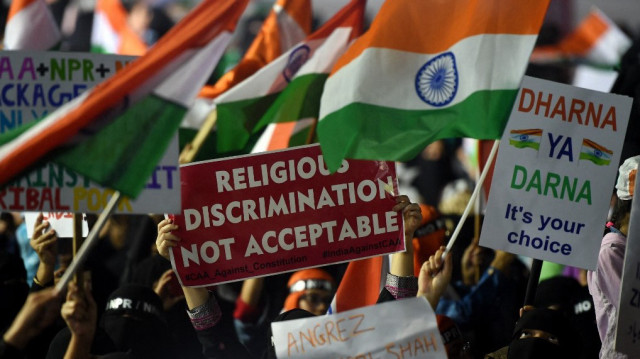 Des femmes brandissent des pancartes et des drapeaux indiens lors d'une manifestation contre la loi d'amendement sur la citoyenneté (CAA) du gouvernement indien, le registre national des citoyens (NRC) et le registre national de la population (NRP), à Mumbai, le 17 janvier 2020.
