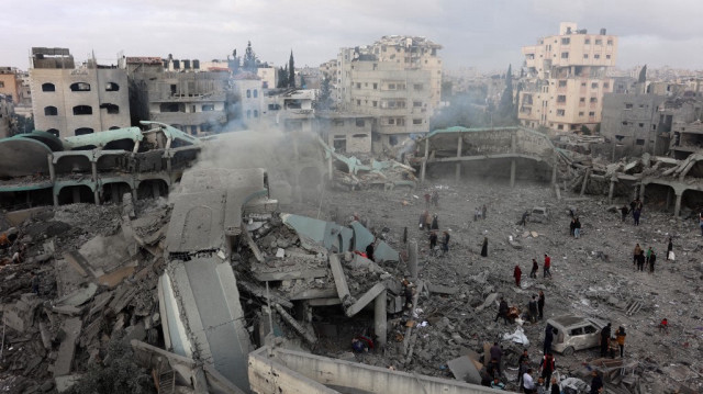 Sur cette vue aérienne, des Palestiniens constatent les dégâts dans la cour d'une école détruite, un jour après qu'elle ait été touchée par une frappe israélienne, dans le quartier d'al-Tuffah de la ville de Gaza, le 4 avril 2025.