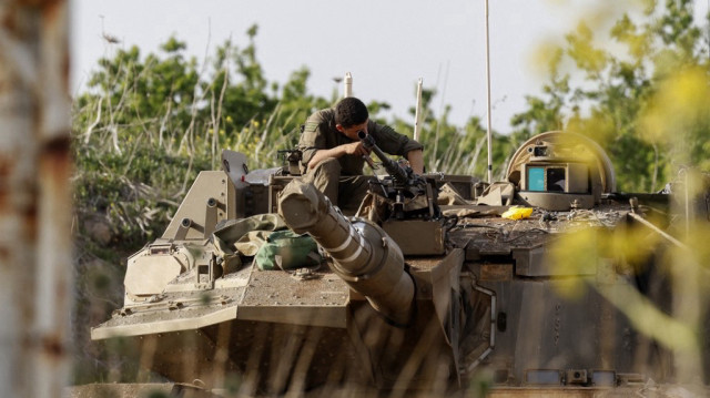 Un soldat israélien vérifie un char de combat Merkava déployé sur une position dans le plateau du Golan annexé par Israël, le long de la frontière avec le sud de la Syrie, le 25 mars 2025.