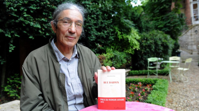 L'auteur franco-algérien Boualem Sansal pose le 21 juin 2012 dans un jardin à Paris avec son livre "Rue Darwin", publié chez Gallimard et récompensé par le Prix du roman arabe 2012.