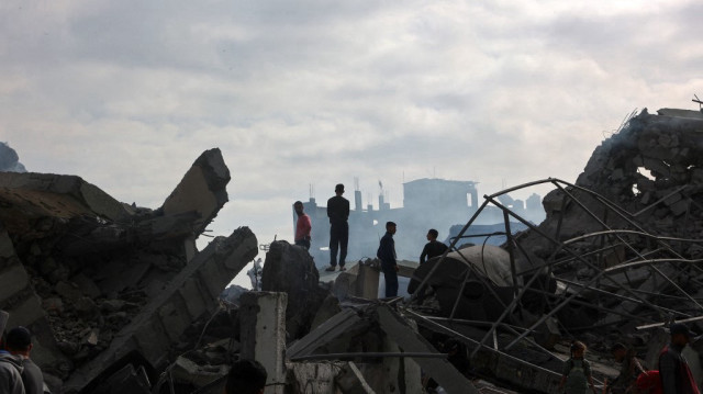 Des Palestiniens se tiennent debout au milieu des décombres d'une école, un jour après qu'elle ait été touchée par une frappe israélienne, dans le quartier d'al-Tuffah de la ville de Gaza, le 4 avril 2025.