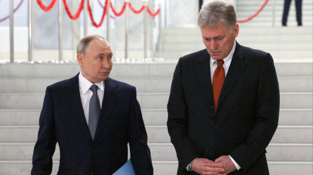 Sur cette photo de famille diffusée par l'agence d'État russe Sputnik, le président russe Vladimir Poutine et le porte-parole du Kremlin Dmitry Peskov sont vus avant une réunion du Conseil économique suprême eurasien dans la station de ski d'Igora, dans la région de Leningrad, le 26 décembre 2024.