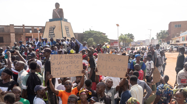 Des partisans du Bloc Républicain pour la Défense de la Constitution (BRDC) tiennent des pancartes lors d'une manifestation contre un troisième mandat du président centrafricain Faustin Archange Touadéra à Bangui le 4 avril 2025.