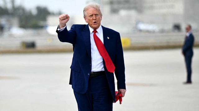 Le président américain Donald Trump frappe du poing à son arrivée à l'aéroport international de Miami, le 3 avril 2025. Donald Trump se rend au Trump National Doral Golf Club avant de se rendre à son Mar-a-Lago Resort.