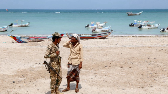 Un soldat des garde-côtes yéménites parle avec un homme sur la plage dans la région d'Al-Khokha du gouvernorat d'Al-Hodeidah, dans l'ouest du pays déchiré par la guerre, le 1er juin 2024.