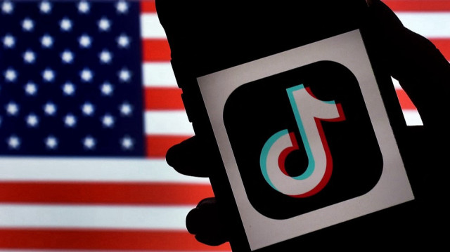 Sur cette photo d'illustration, le logo de l'application de médias sociaux TikTok est affiché sur l'écran d'un iPhone sur fond de drapeau américain, le 3 août 2020 à Arlington, en Virginie.