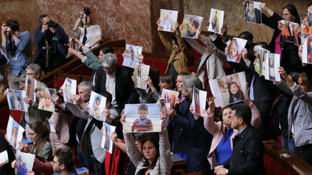 Des députés de gauche tiennent des portraits d'enfants qui ont été tués lors de l'offensive militaire israélienne à Gaza, lors d'une séance de questions au gouvernement à l'Assemblée nationale, la chambre basse du Parlement français, à Paris, le 8 avril 2025.