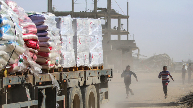 Des enfants palestiniens courent après un camion chargé d'aide humanitaire qui traverse Rafah, dans le sud de la bande de Gaza, après avoir franchi le point de passage de Kerem Shalom, le 18 février 2025. La fragile trêve de Gaza entre Israël et le Hamas est entrée en vigueur le 19 janvier après plus de 15 mois de combats, déclenchés par l'attaque du groupe militant palestinien contre Israël le 7 octobre 2023.