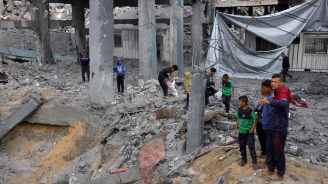 Des Palestiniens se rassemblent au milieu des décombres d'un dépôt d'aide et d'un abri de l'UNRWA, lourdement endommagés lors d'une frappe israélienne à Jabalia, dans le nord de la bande de Gaza, le 10 mai 2025.