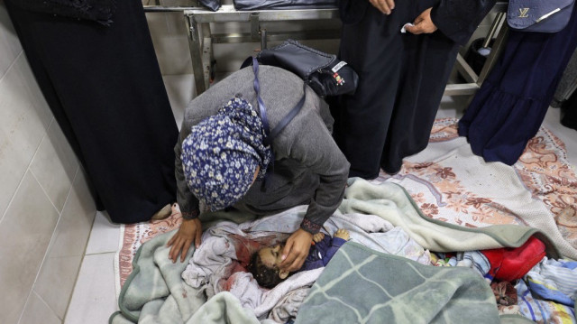 Une femme pleure le corps enveloppé de Farah Ahmed, qui a été tuée avec d'autres membres de sa famille lorsqu'une frappe israélienne a touché leur maison, alors qu'elle repose à l'hôpital Al-Awda dans le camp de réfugiés de Nuseirat, dans le centre de la bande de Gaza, le 30 avril 2025.