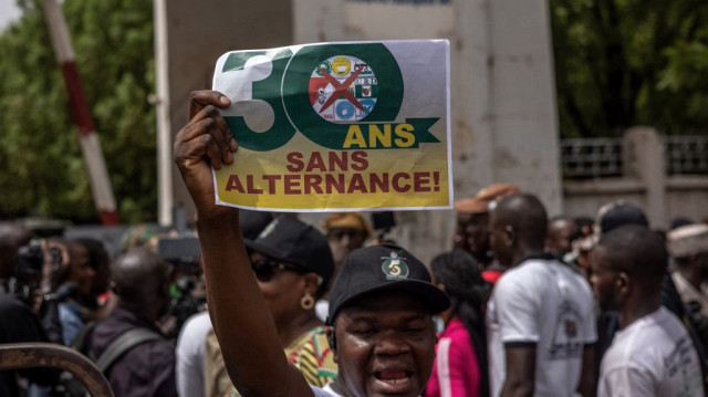 Un manifestant pro-junte tient une bannière alors que les partis politiques opposés protestent contre une dissolution potentielle par les autorités militaires du Mali à Bamako le 3 mai 2025.