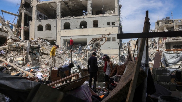 Des personnes cherchent des objets récupérables dans les décombres d'un bâtiment touché par une frappe israélienne à Jabalia, dans le nord de la bande de Gaza, le 15 mai 2025. Les combats font rage à Gaza, où les responsables de la défense civile ont déclaré à l'AFP que 80 personnes avaient été tuées par les bombardements israéliens le 14 mai, dont 59 dans le nord.