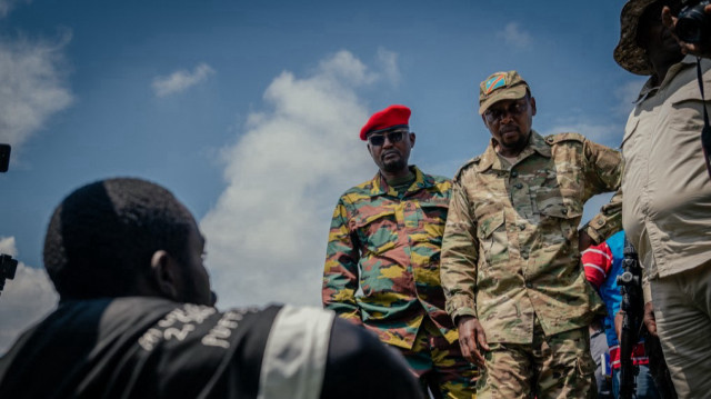 Le colonel Willy Ngoma (à droite), porte-parole militaire du M23, et Jimmy, le commandant rebelle en charge de la ville, vérifient les documents d'identité des civils au Stade de l'Unité, à Goma, le 13 mai 2025.