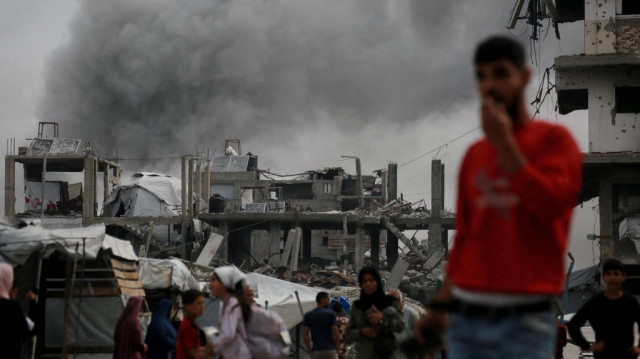 De la fumée s'élève à l'arrière-plan alors qu'une frappe israélienne touche la maison de la famille Hmeid à Jabalia, dans le nord de la bande de Gaza, le 15 mai 2025.