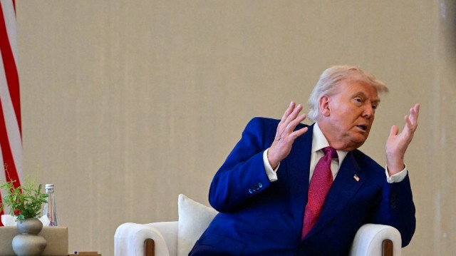 Le président américain Donald Trump s'entretient avec son homologue des Émirats arabes unis (non représenté) à son arrivée au terminal présidentiel d'Abou Dhabi, le 15 mai 2025. Les Émirats arabes unis constituent la troisième étape de la visite de Donald Trump dans la région, qui l'a déjà conduit en Arabie saoudite et au Qatar.