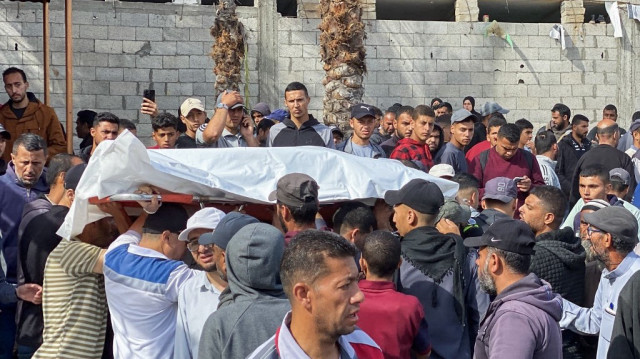 Des Palestiniens portent le corps d'une victime des frappes israéliennes avant son enterrement, à l'hôpital Nasser de Khan Yunis, dans le sud de la bande de Gaza, le 15 mai 2025.