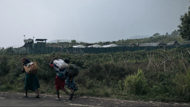Des femmes passent devant une position militaire de la Mission de stabilisation de l'Organisation des Nations Unies en République démocratique du Congo (MONUSCO) dans la banlieue de Goma, le 2 février 2025.