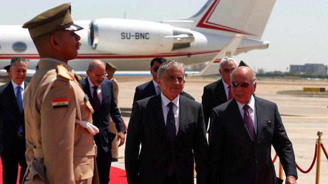 Le ministre irakien des Affaires étrangères, Fuad Hussein (à droite), marche avec le Premier ministre jordanien, Jaafar Hassan (à gauche), à son arrivée à l'aéroport international de Bagdad, avant le 34e sommet de la Ligue arabe, le 17 mai 2025.