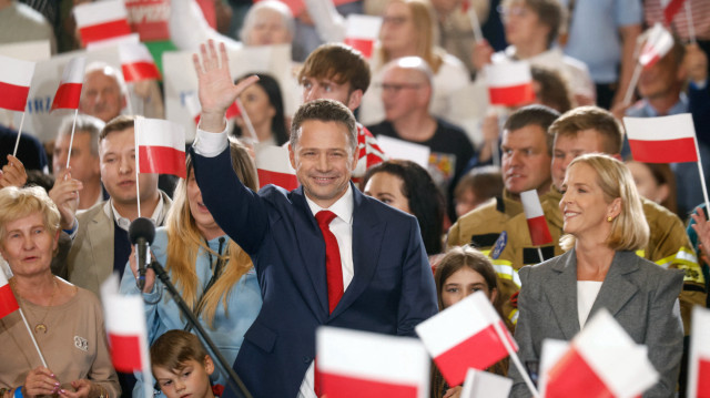 Rafal Trzaskowski, candidat à l'élection présidentielle, maire de Varsovie et membre du parti au pouvoir, la Coalition civique, salue ses partisans après l'annonce des premiers sondages de sortie des urnes à Sandomierz, le 18 mai 2025.