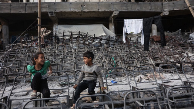 Des enfants palestiniens déplacés jouent dans un amphithéâtre endommagé du campus de l'université islamique de Gaza, le 1er mai 2025.