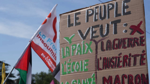 Une pancarte est brandie lors d'un défilé le jour du 1er mai 2025, à Nantes, en France. 
