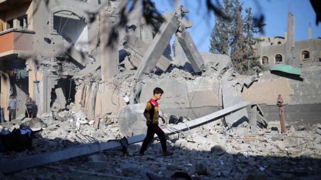 Un jeune Palestinien marche au milieu des décombres, suite aux frappes israéliennes de la nuit, dans le camp de réfugiés de Nuseirat, dans le centre de la bande de Gaza, le 29 avril 2025.