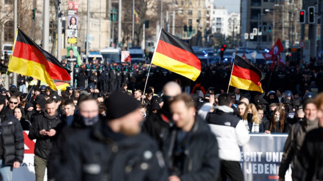 Des personnes agitent des drapeaux allemands lors d'une marche de partisans de l'extrême droite le 22 février 2025 à Berlin, un jour avant les élections générales.