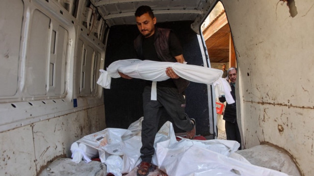 Un Palestinien transporte le corps d'un enfant dans une camionnette contenant les corps des personnes tuées lors des frappes aériennes israéliennes de la nuit, le 21 mai 2025.