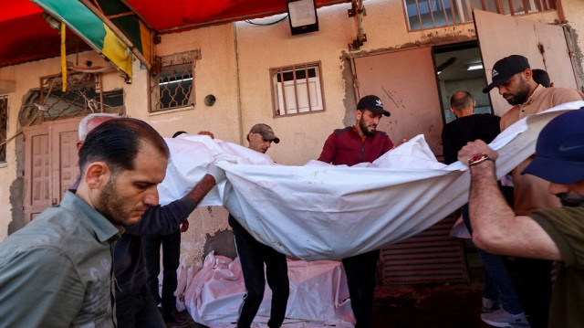 Des hommes portent le corps d'un Palestinien tué lors de frappes israéliennes, avant une procession funéraire à l'hôpital des Martyrs d'al-Aqsa à Deir el-Balah, dans le centre de la bande de Gaza, le 20 mai 2025.