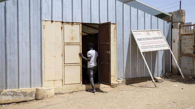 Un homme entre dans un bâtiment abritant un centre temporaire de la Croix-Rouge pour les migrants à Rosso, au Sénégal, le 20 mars 2025. Depuis plusieurs semaines, la Mauritanie mène une campagne massive d'expulsion des migrants des pays voisins, provoquant l'émoi dans la région. Parmi eux : Sénégalais, Maliens, Ivoiriens, Guinéens, etc. Ce pays largement désertique d'Afrique de l'Ouest, situé sur la côte atlantique, est le point de départ de nombreux migrants de tout le continent qui tentent de rejoindre l'Europe par la mer.