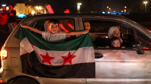 Des habitants célèbrent sur la place des Omeyyades à Damas après la décision du président américain Donald Trump de lever les sanctions en Syrie, le 13 mai 2025.
