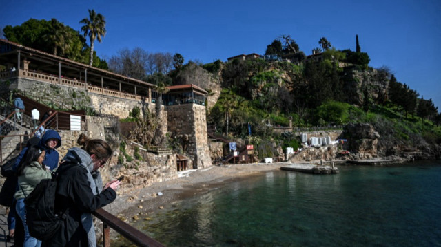 Des touristes se tiennent près de la plage de la marina de Kaleici à Antalya.