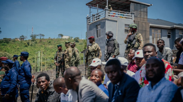 Des soldats rebelles du M23 assurent la sécurité, certains assis sur des toits près du stade, d'autres dans des pick-up près des tribunes, lors d'un service d'action de grâce organisé par l'administration du M23/AFC au Stade de l'Unité à Goma, le 18 mai 2025.