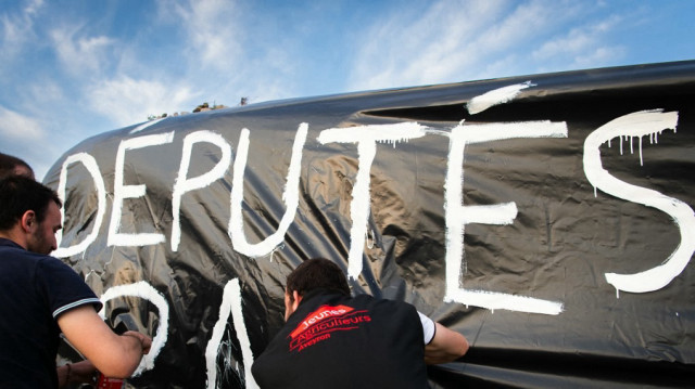 Des agriculteurs du syndicat Jeunes Agriculteurs (JA) d'Occitanie manifestent en faveur de la proposition de loi Duplomb visant à "lever les contraintes pesant sur l'exercice" de leur profession et notamment à faciliter l'accès aux pesticides, devant l'aéroport de Rodez, dans le sud de la France, le 15 mai 2025.