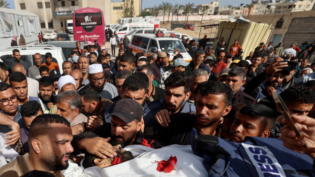 Des personnes en deuil font leurs adieux au journaliste palestinien Hassan Aslih, tué à l'aube lors d'une frappe israélienne qui a touché le bâtiment de chirurgie de l'hôpital Nasser, lors de sa procession funéraire à Khan Yunis, dans le sud de la bande de Gaza, le 13 mai 2025. L'armée israélienne a déclaré avoir frappé un hôpital de Gaza "abritant des militants du Hamas" lors d'un raid le 13 mai qui, selon le groupe palestinien, a tué le journaliste qui avait été blessé lors d'une attaque israélienne le mois dernier, ainsi qu'un certain nombre de civils.