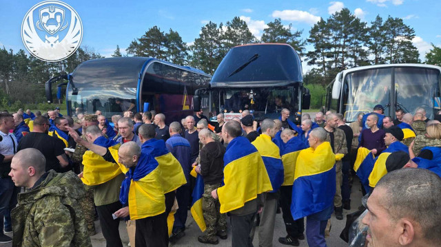 Sur cette photo prise et diffusée par le service de presse présidentiel ukrainien le 24 mai 2025, des prisonniers de guerre ukrainiens enveloppés de drapeaux nationaux réagissent à la suite d'un échange dans un lieu non divulgué, dans le contexte de l'invasion russe en Ukraine. La Russie et l'Ukraine ont échangé 307 prisonniers de guerre de chaque pays le 24 mai 2025, a déclaré le ministère russe de la défense au deuxième jour du plus important échange de prisonniers en plus de trois ans de conflit.