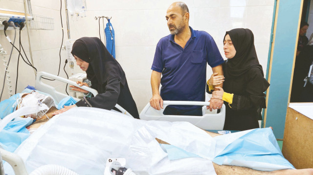 9 çocuğunu kaybeden doktor Alaa Neccar, ağır yaralı eşinin başında saatlerce ağladı.