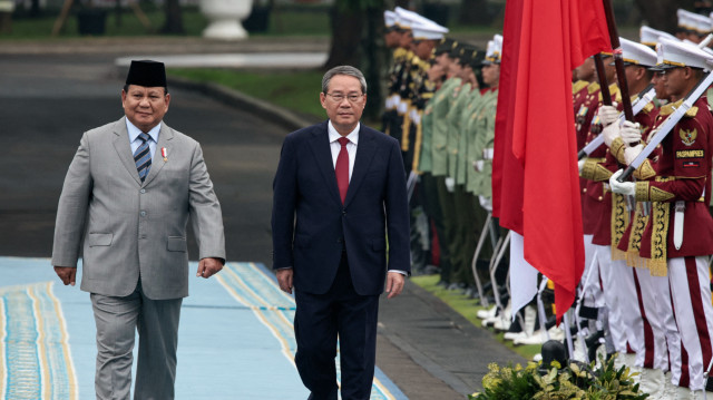 Le président indonésien Prabowo Subianto (à gauche) et le premier ministre chinois Li Qiang inspectent une garde d'honneur lors d'une cérémonie de bienvenue au palais présidentiel de Jakarta, le 25 mai 2025.
