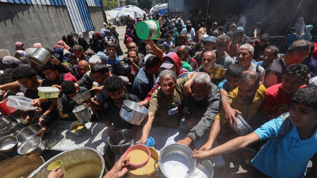 Des Palestiniens font la queue pour un repas chaud dans une cuisine caritative gérée par le Programme alimentaire mondial (PAM) des Nations unies dans le camp de réfugiés de Nuseirat, dans le centre de la bande de Gaza, le 26 avril 2025. L'agence alimentaire des Nations unies, l'un des principaux fournisseurs d'aide alimentaire dans le territoire palestinien assiégé, a déclaré le 25 avril qu'elle avait "livré ses derniers stocks de nourriture aux cuisines de repas chauds dans la bande de Gaza", où Israël bloque toute aide depuis plus de sept semaines, ajoutant que "ces cuisines devraient être complètement à court de nourriture dans les jours à venir".