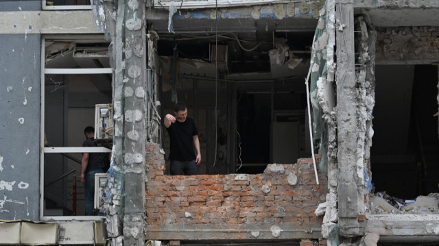 Un habitant se tient dans un appartement endommagé d'un immeuble résidentiel à plusieurs étages suite à une attaque de drone à Kiev le 25 mai 2025, dans le cadre de l'invasion russe en Ukraine. 