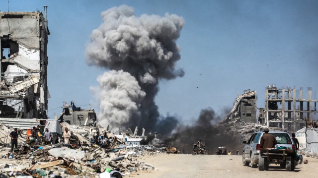 Des personnes regardent des volutes de fumée après une frappe israélienne à Jabalia, dans le nord de la bande de Gaza, le 25 mai 2025.