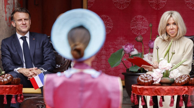 Le président français Emmanuel Macron (G) et son épouse Brigitte Macron assistent à une cérémonie au Temple de la littérature à Hanoï, le 26 mai 2025.