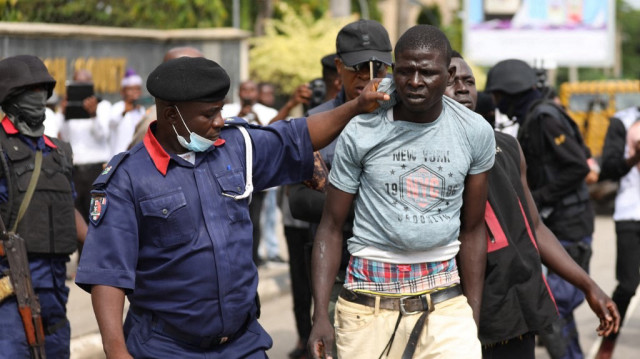 Des officiers de la police nigériane arrêtent des personnes lors du procès du chef du peuple autochtone du Biafra (IPOB), Nnamdi Kanu, qui fait face à une accusation modifiée de 7 chefs d'accusation pour crime de trahison et terrorisme à la Haute Cour fédérale d'Abuja, au Nigeria, le 21 octobre 2021.