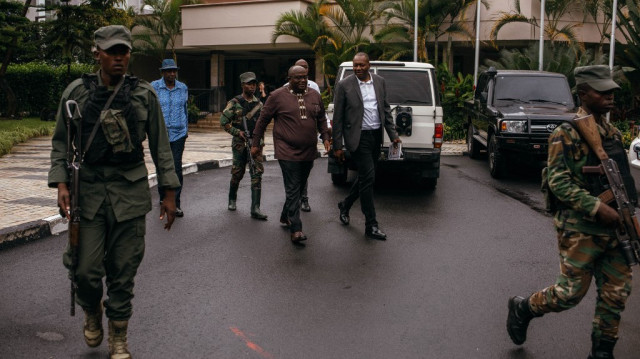 Le chef du mouvement M23, Bertrand Bisimwa (C), et son porte-parole, Lawrence Kanyuka, quittent une conférence de presse tenue à l'hôtel Serena de Goma, le 25 mai 2025.