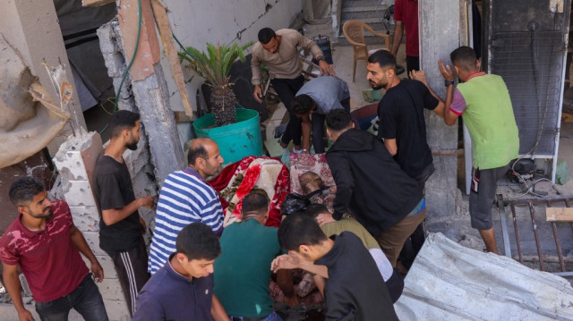 Des Palestiniens portent le corps d'un homme tué lors d'une frappe israélienne dans le quartier de Saftawi, à l'ouest de Jabalia, dans le nord de la bande de Gaza, le 27 mai 2025.