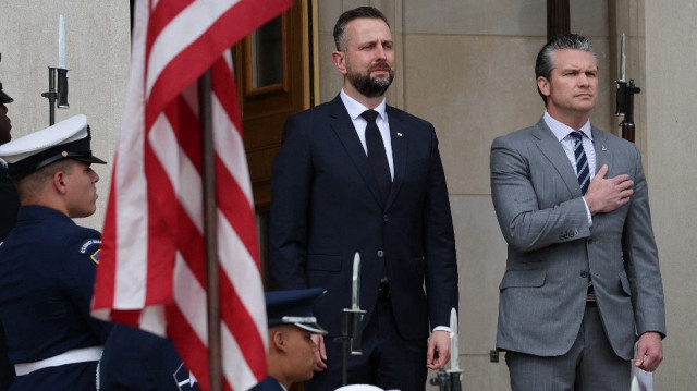 Le secrétaire américain à la Défense Pete Hegseth (à droite) et le vice-premier ministre et ministre de la Défense polonais Wladyslaw Kosinak-Kamysz (à gauche) écoutent l'hymne national des États-Unis lors de la visite de Kosinak-Kamyszto au Pentagone, le 27 mai 2025 à Arlington, en Virginie.