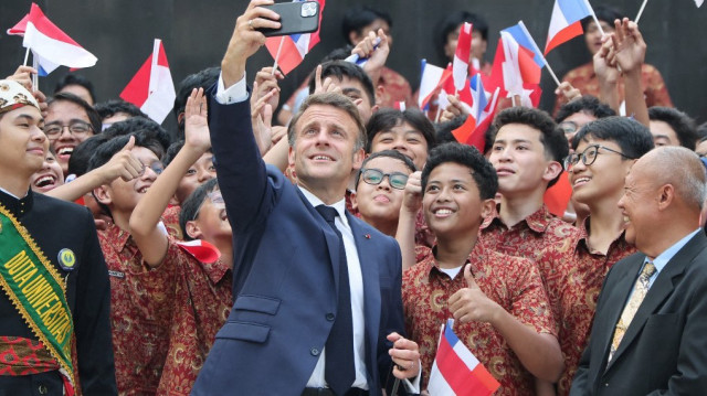 Le président français Emmanuel Macron (C) pose pour des photos avec des étudiants lors de sa visite à l'université nationale de Jakarta, le 28 mai 2025.