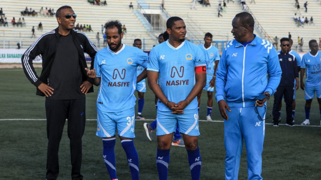 La légende camerounaise du football Samuel Eto'o (2e à droite) et le Premier ministre somalien Hamza Abdi Barre (à gauche) posent aux côtés d’anciennes gloires du football somalien avant un match de gala soutenu par la FIFA, opposant une équipe internationale à une sélection locale, au Stade national de Mogadiscio, le 27 mai 2025.